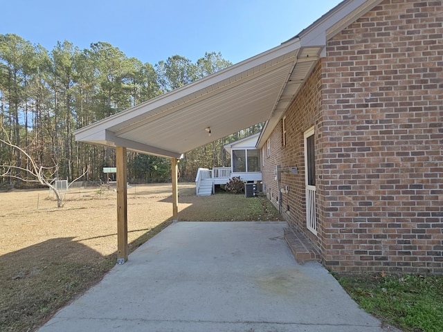 view of patio / terrace featuring central air condition unit and a sunroom