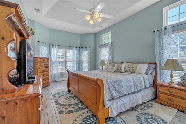144 Back Tee Cir, Summerville, SC 29485 - bedroom with visible vents, a tray ceiling, ceiling fan, and light wood-type flooring