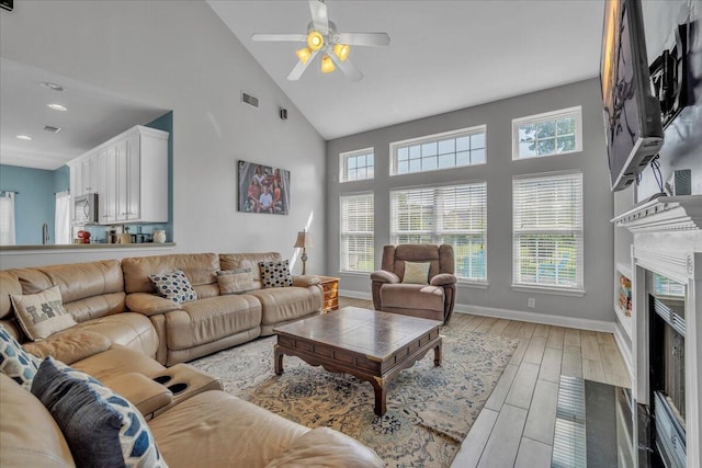 144 Back Tee Cir, Summerville, SC 29485 - living area with high vaulted ceiling, baseboards, light wood finished floors, a high end fireplace, and a ceiling fan
