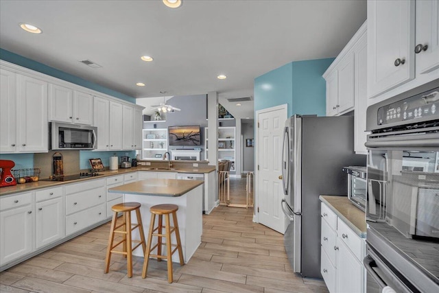 144 Back Tee Cir, Summerville, SC 29485 - kitchen featuring white cabinetry, light wood finished floors, a breakfast bar area, and appliances with stainless steel finishes