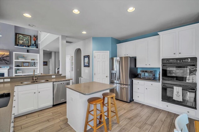 144 Back Tee Cir, Summerville, SC 29485 - kitchen with white cabinets, stainless steel appliances, arched walkways, wood tiled floor, and a sink