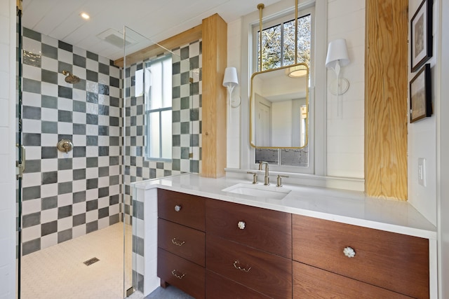 full bath featuring vanity and a tile shower