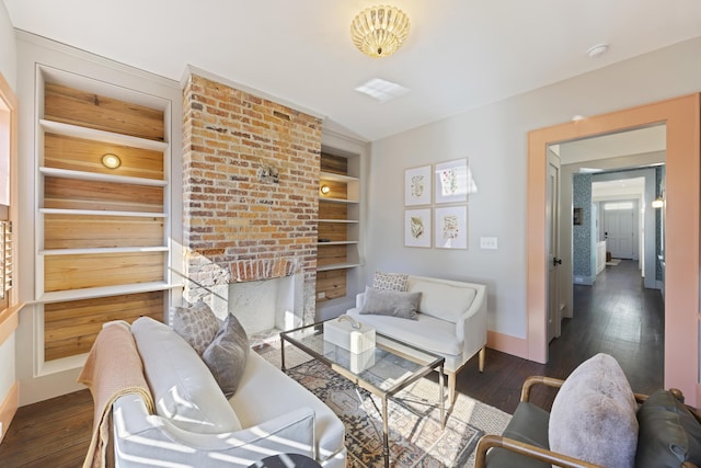 living area featuring built in features, a fireplace, baseboards, and hardwood / wood-style flooring