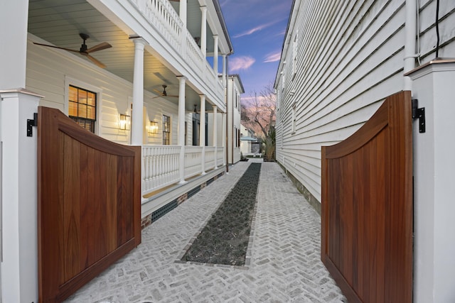 view of side of property featuring a porch and a ceiling fan