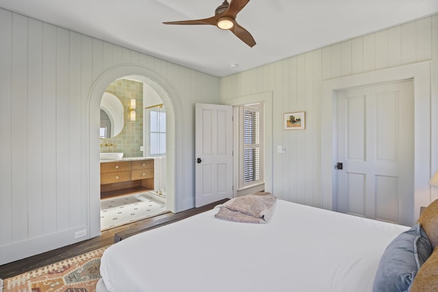 bedroom with ensuite bathroom, a ceiling fan, and wood finished floors