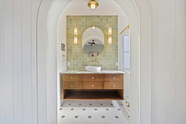 bathroom featuring tasteful backsplash, tile walls, and vanity