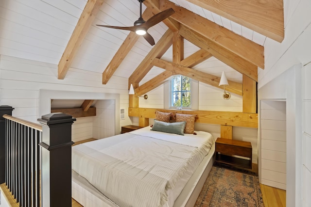 bedroom with lofted ceiling with beams, wooden walls, and wood finished floors