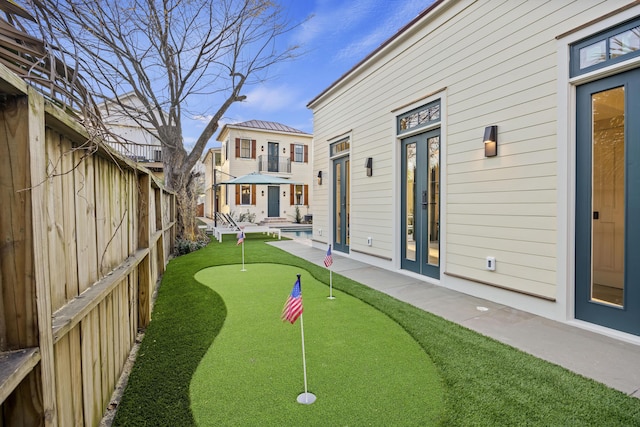 view of yard featuring a patio area, french doors, and a fenced backyard