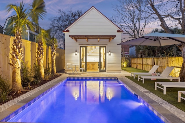 view of pool featuring an outdoor structure, a storage structure, a fenced backyard, and a fenced in pool