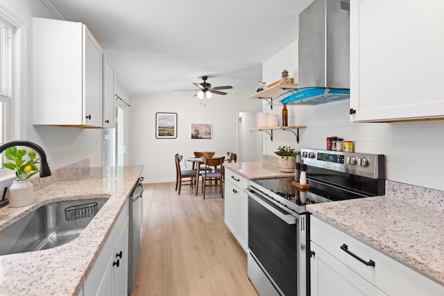 kitchen featuring stainless steel appliances, a sink, exhaust hood, light wood-style floors, and a ceiling fan