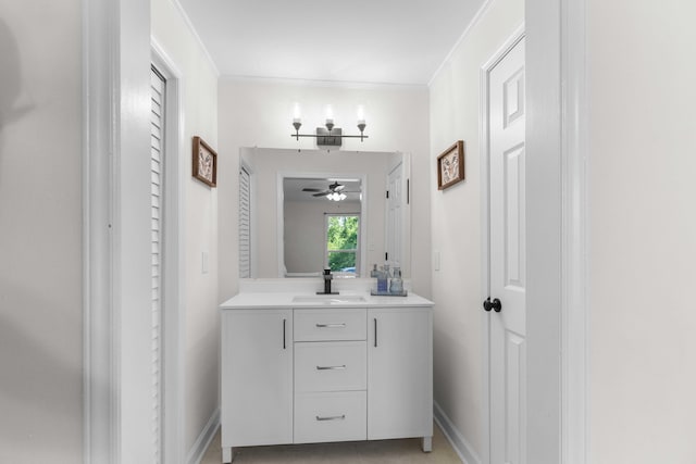 bathroom with ceiling fan, vanity, baseboards, and ornamental molding