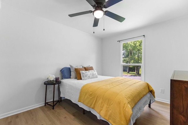 bedroom with wood finished floors, baseboards, and ceiling fan