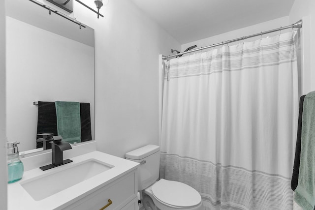 bathroom with toilet, vanity, and curtained shower