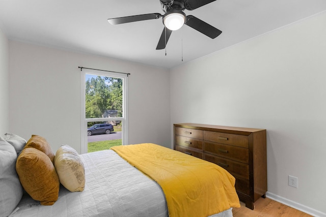 bedroom featuring light wood finished floors, baseboards, and ceiling fan
