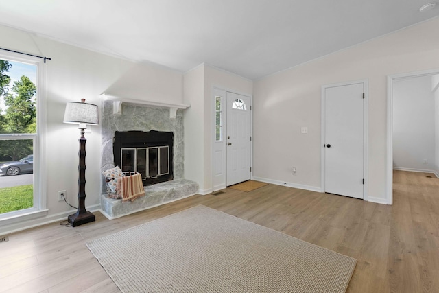 unfurnished living room featuring wood finished floors, a fireplace, and baseboards
