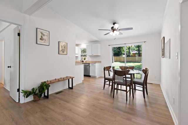 dining space with ceiling fan, light wood finished floors, and baseboards