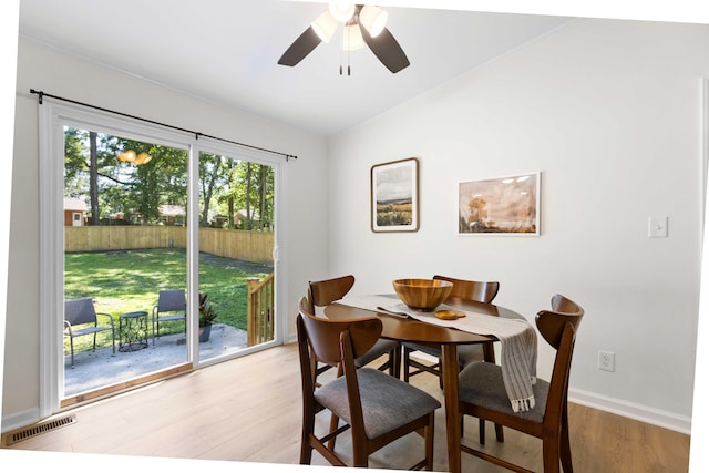 dining space with light wood-type flooring, ceiling fan, baseboards, and lofted ceiling