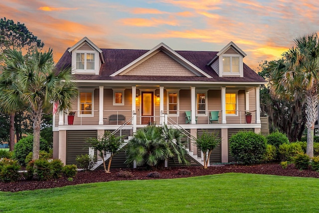 view of front facade with a lawn and covered porch