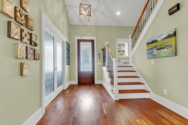 foyer featuring hardwood / wood-style floors, a chandelier, french doors, and a healthy amount of sunlight