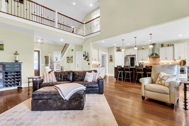 living room with hardwood / wood-style flooring and high vaulted ceiling