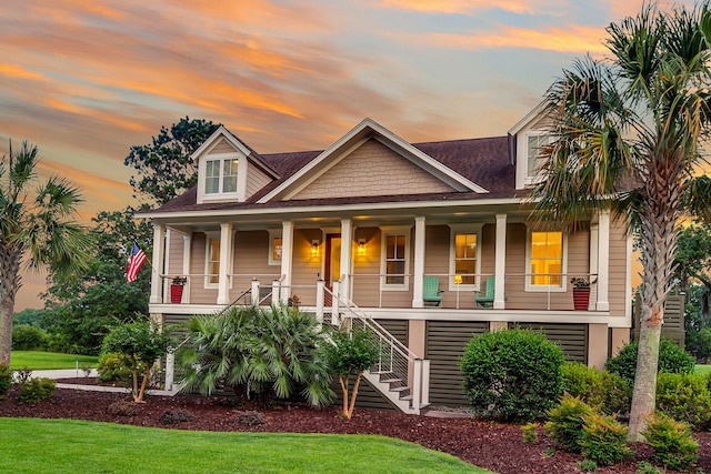 view of front of home featuring covered porch and a lawn