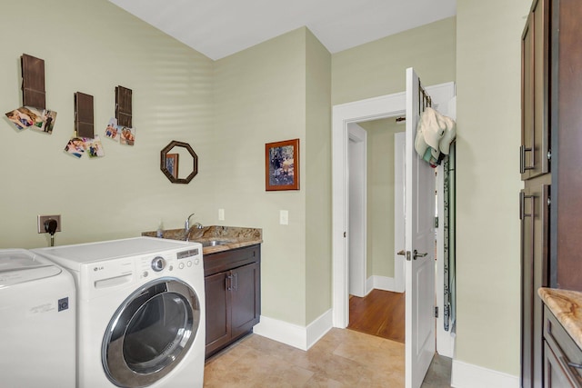 clothes washing area with cabinets, separate washer and dryer, sink, and light tile patterned floors