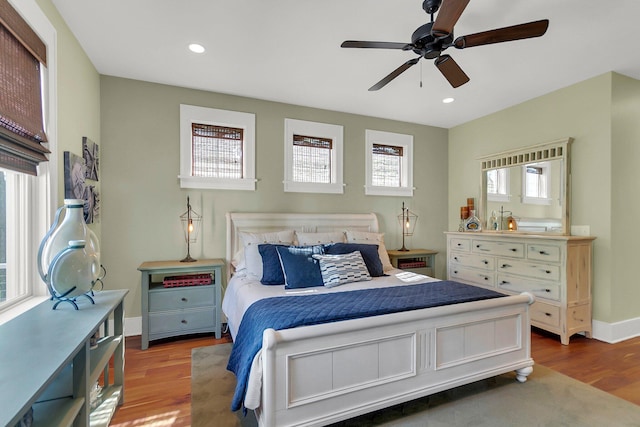 bedroom with light wood-type flooring, multiple windows, and ceiling fan