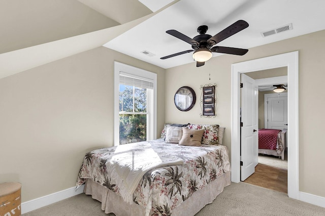 bedroom with ceiling fan, lofted ceiling, and light colored carpet