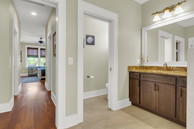 bathroom featuring hardwood / wood-style floors, vanity, ceiling fan, and toilet