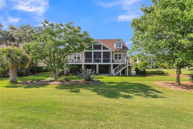 rear view of house featuring a lawn and a sunroom