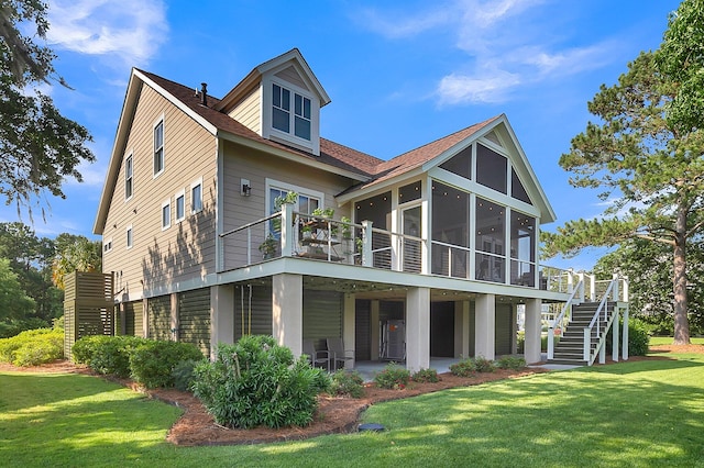 rear view of property featuring a patio, a sunroom, and a lawn