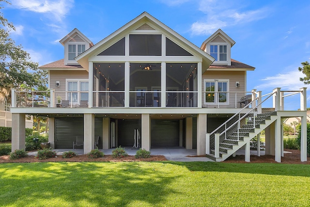 rear view of property with a deck, a sunroom, and a yard