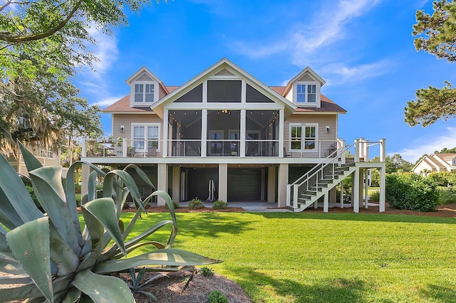 rear view of house featuring a sunroom and a yard