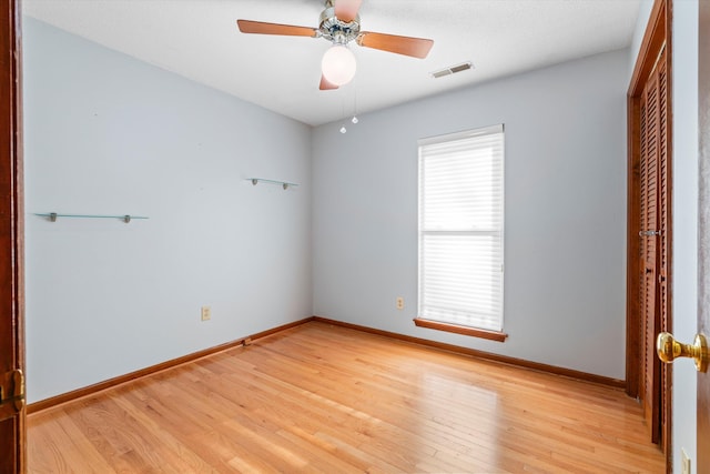 unfurnished room with visible vents, baseboards, light wood-style floors, and ceiling fan