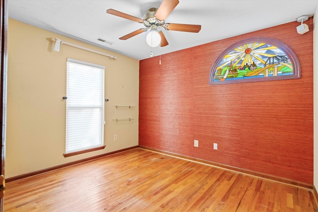 unfurnished room with visible vents, baseboards, light wood-style floors, and a ceiling fan