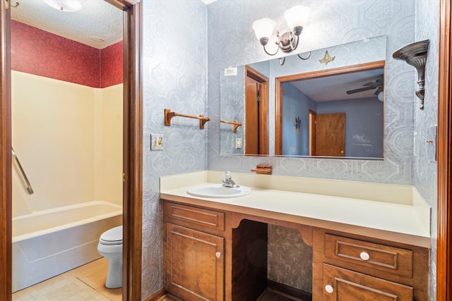 bathroom featuring vanity, a textured ceiling, wallpapered walls, shower / washtub combination, and toilet