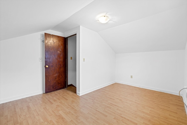 bonus room featuring vaulted ceiling, light wood-style flooring, and baseboards