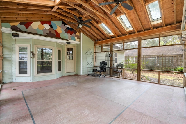 unfurnished sunroom featuring vaulted ceiling with skylight and ceiling fan