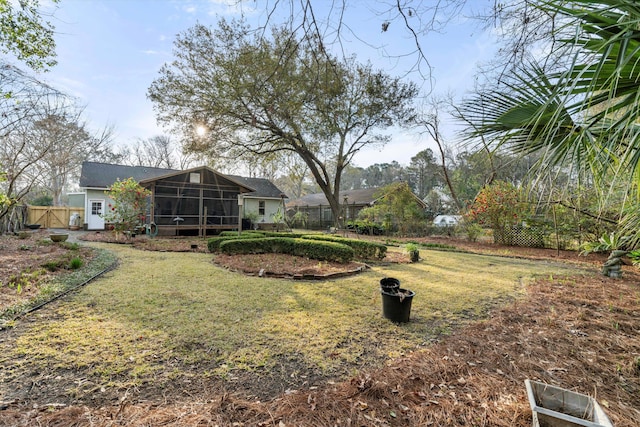 view of yard featuring fence and a sunroom