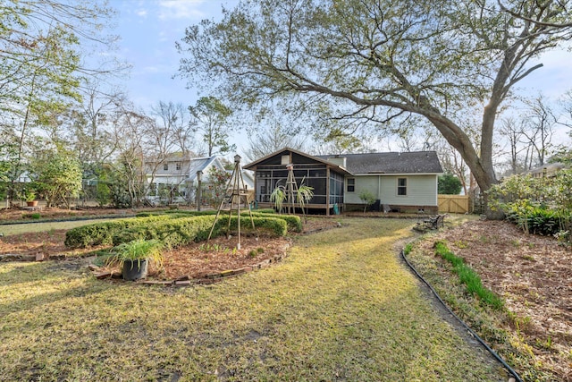 view of yard featuring a gate, fence, and a sunroom