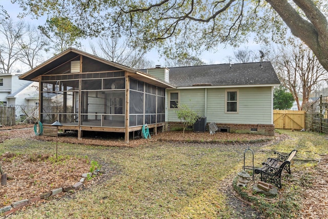 rear view of house with a sunroom, fence, a shingled roof, crawl space, and a chimney