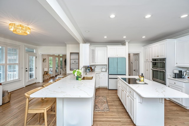 1143 Sea Eagle Watch, Charleston, SC 29412 - kitchen with paneled refrigerator, stainless steel double oven, ornamental molding, a breakfast bar, and black electric stovetop