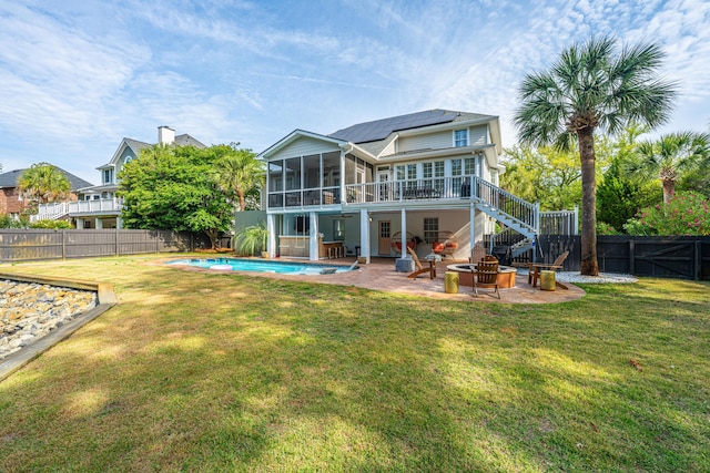1143 Sea Eagle Watch, Charleston, SC 29412 - back of property featuring a sunroom, an outdoor fire pit, roof mounted solar panels, a patio, and a fenced backyard