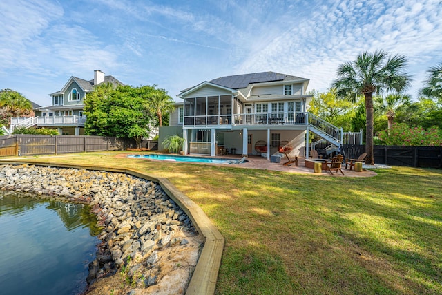 1143 Sea Eagle Watch, Charleston, SC 29412 - back of property featuring a sunroom, stairs, a fenced backyard, a patio area, and roof mounted solar panels