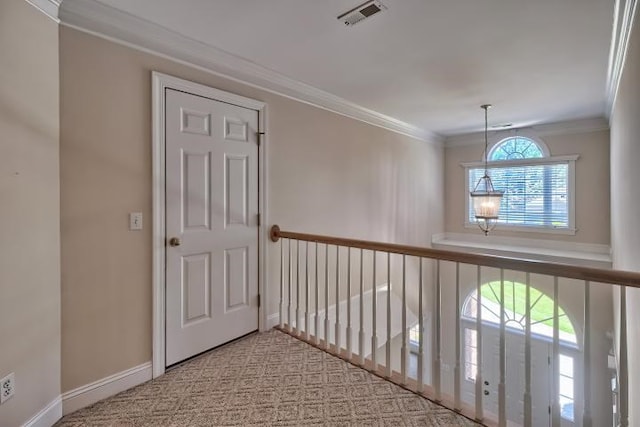 hall featuring light colored carpet, plenty of natural light, and crown molding