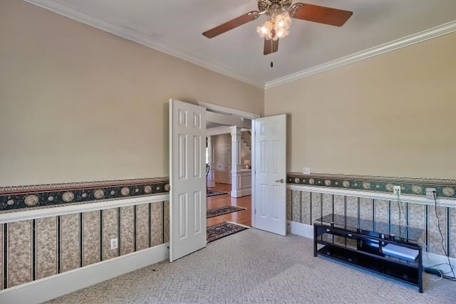 carpeted bedroom with decorative columns, crown molding, and ceiling fan