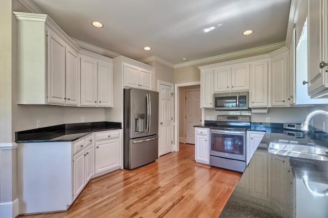 kitchen featuring stainless steel appliances, crown molding, and white cabinets