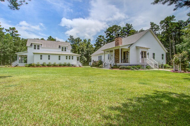 105 Bobcat Ln, Ravenel, SC 29470 - view of front facade with a porch, a chimney, and a front lawn