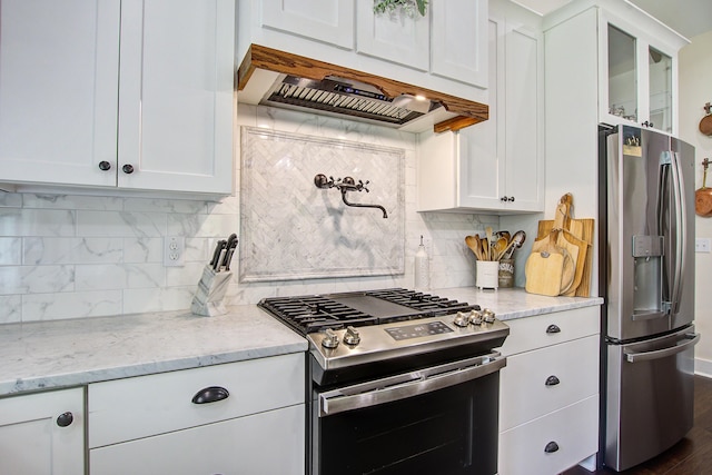 105 Bobcat Ln, Ravenel, SC 29470 - kitchen featuring stainless steel appliances, extractor fan, white cabinetry, tasteful backsplash, and light stone countertops