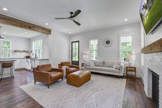 105 Bobcat Ln, Ravenel, SC 29470 - living area with healthy amount of natural light, dark wood finished floors, a ceiling fan, a fireplace, and wooden walls